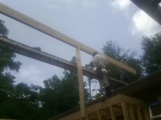 Carpenter setting a ridge beam over a new addition frame — Ice Dam Removal by Roofing Brothers in Yellville
