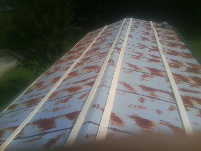 Rusted metal roof panels with new wood purlins before replacement — Storm Damage Roof Repair in Yellville by Roofing Brothers