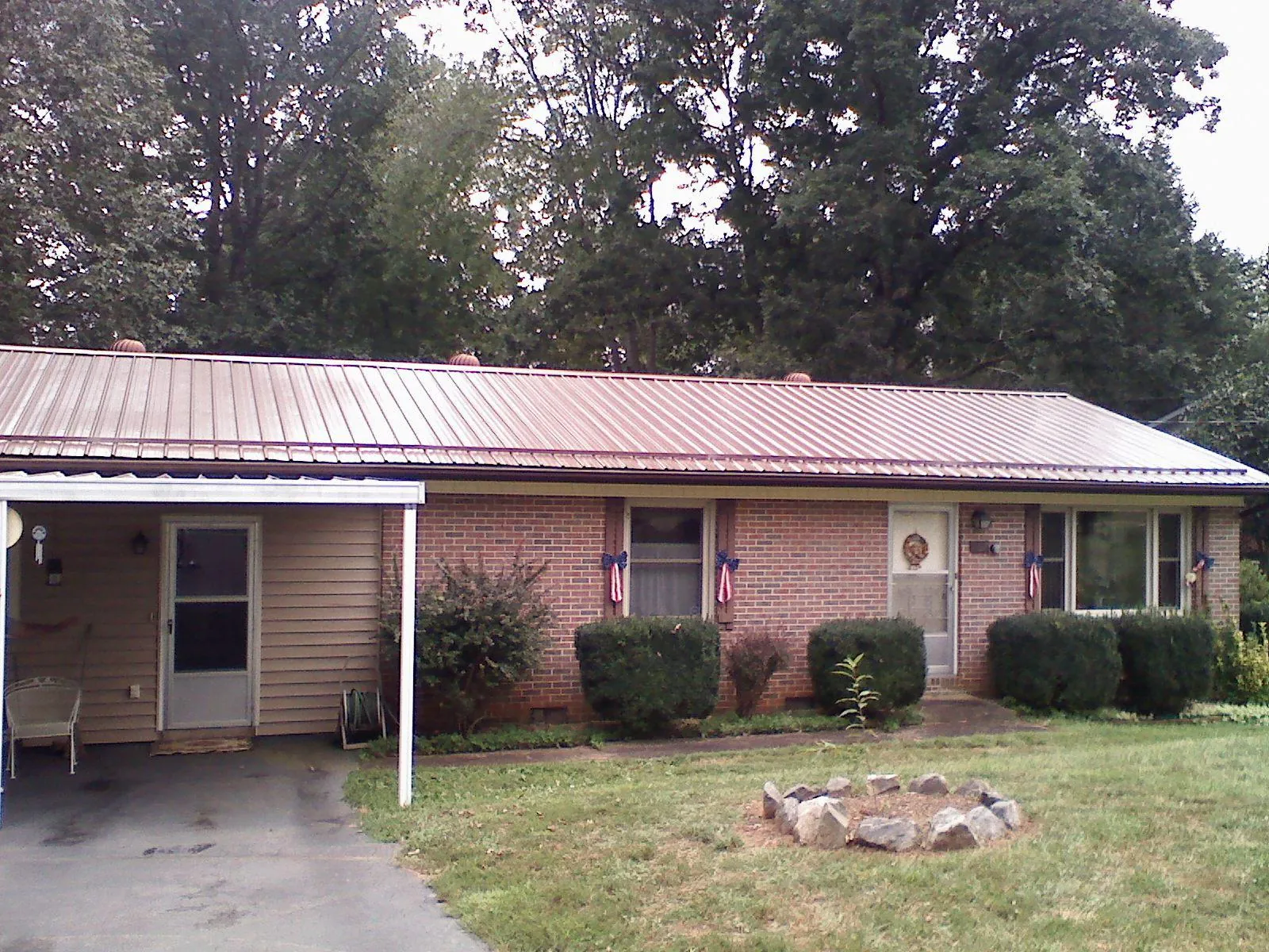 Bronze metal roof and carport on a brick ranch home — Roof Repair work by our crew in Yellville