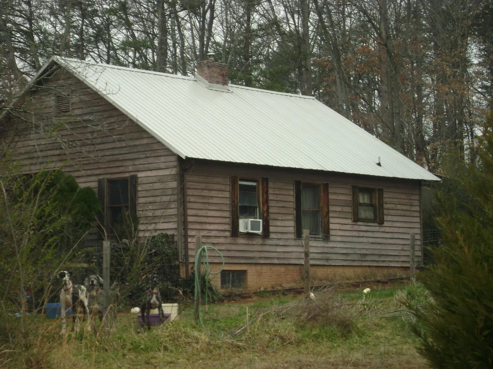 White metal roof on an old wood sided farmhouse, from a Metal Roof Installation job in Yellville
